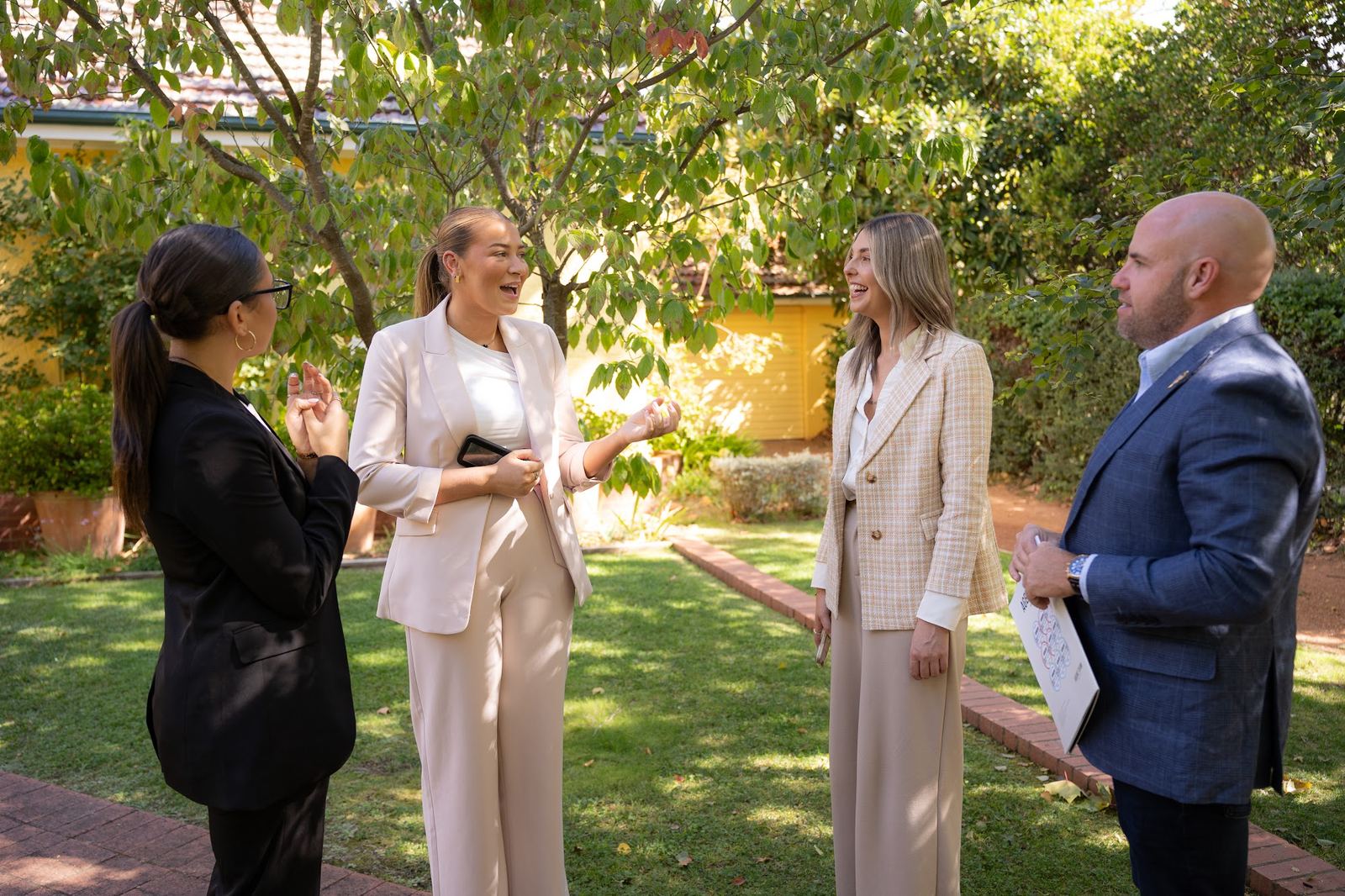 The Agent Team team talking with clients in a Canberra garden
