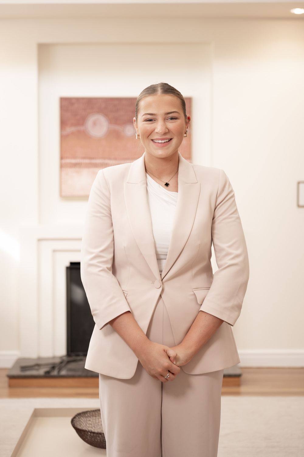 Tiff Mills of Agent Team in front of a fireplace in a styled Canberra home